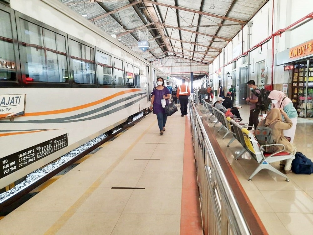 Pelanggan KAI hendak memasuki kereta api di Stasiun Madiun min